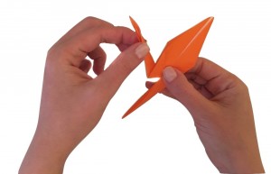 Hands folding a crane